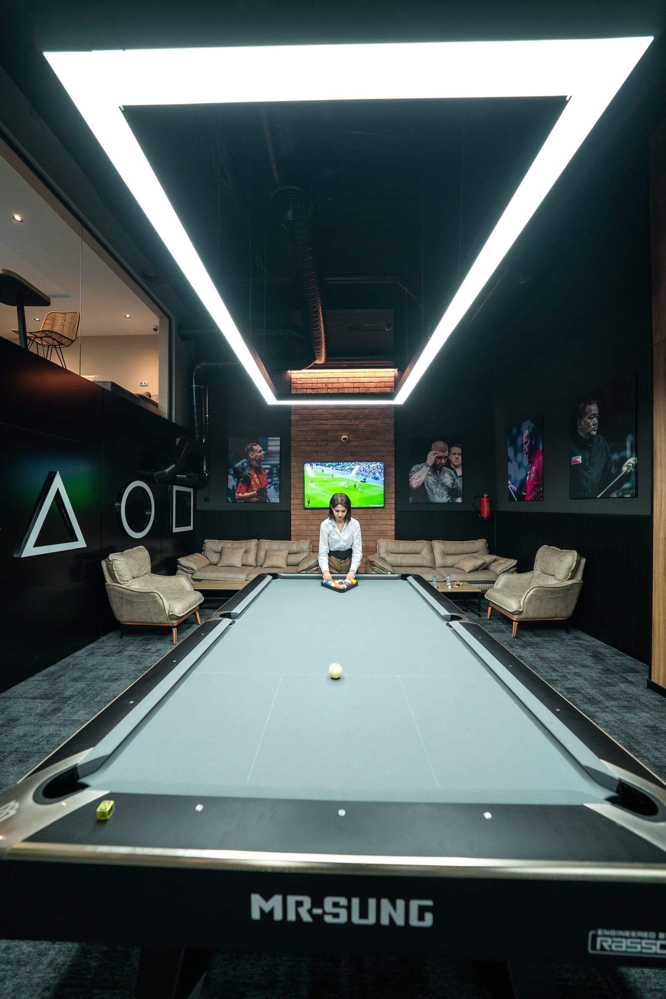 American pool table next to a lounge with sofas